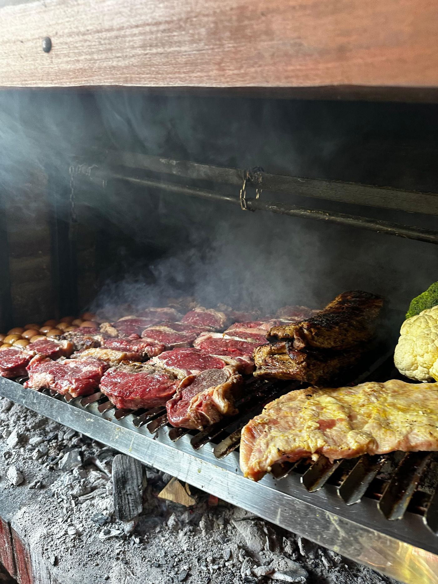 Cortes premium dorándose sobre la parrilla entre el humo